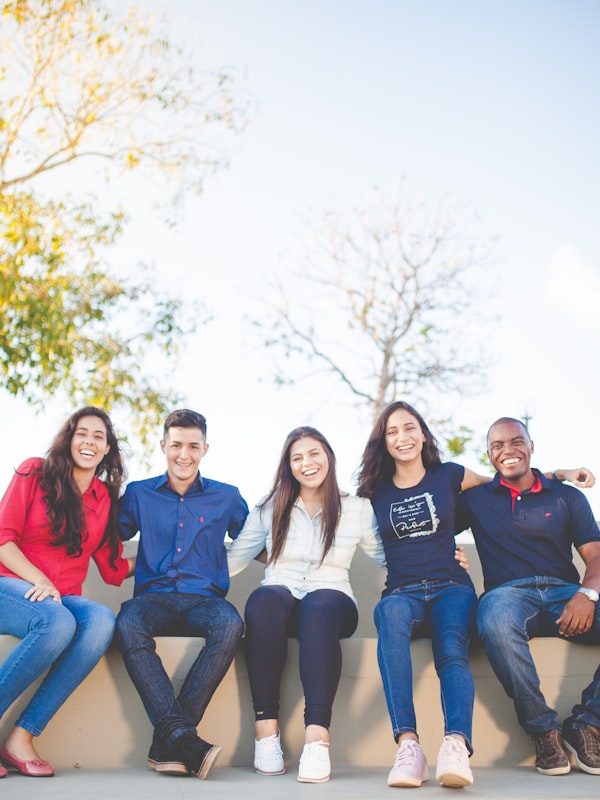 Diverse group of teenagers sitting together outdoors, smiling