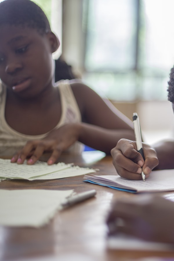Young teen focused and writing at a desk in a bright community space